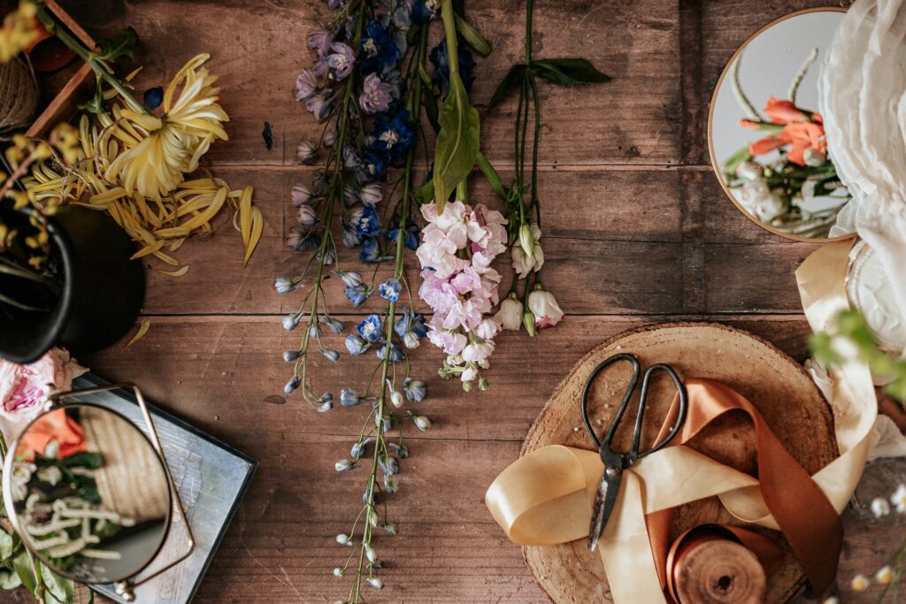 Dried flowers, ribbons and a pair of scissors in a composition