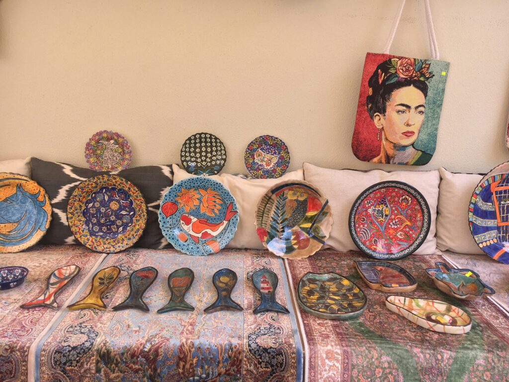 Handmade plates and sculptures laid out on a table for sale