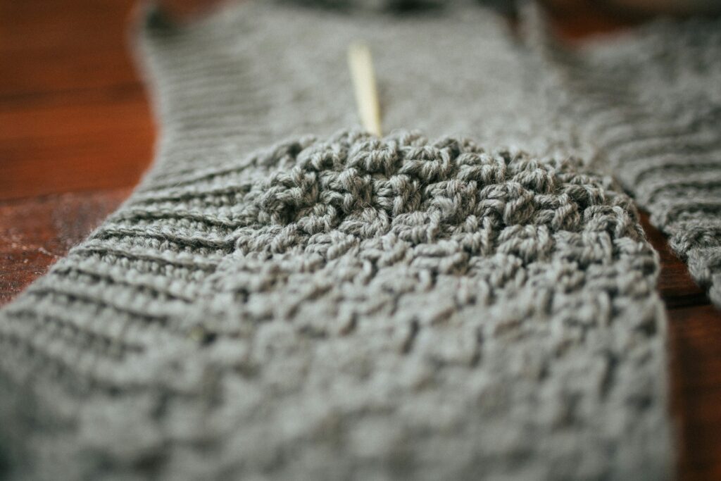 Half-finished knit sweater as a representation of knitting patterns