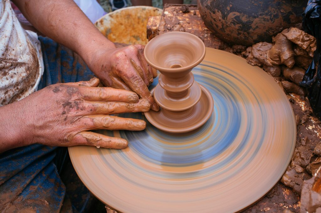 Handmaking a vase on a pottery wheel